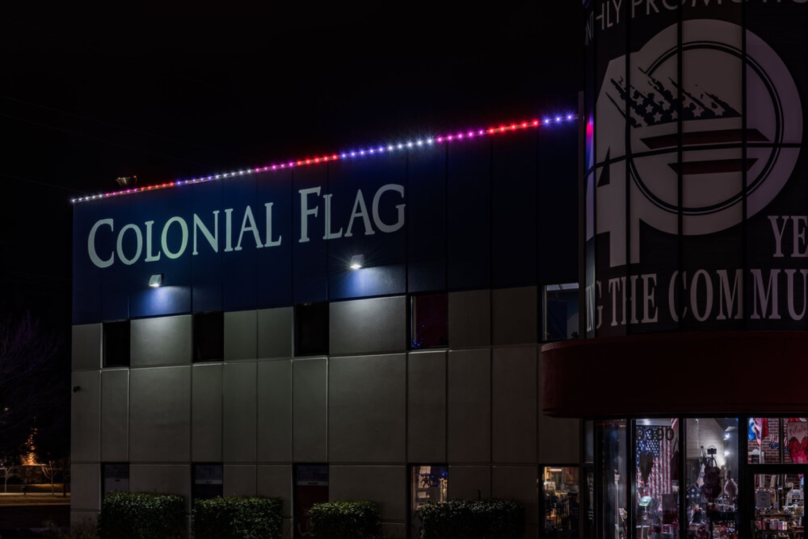 Multicolor permanent lighting on the roofline of a flag store