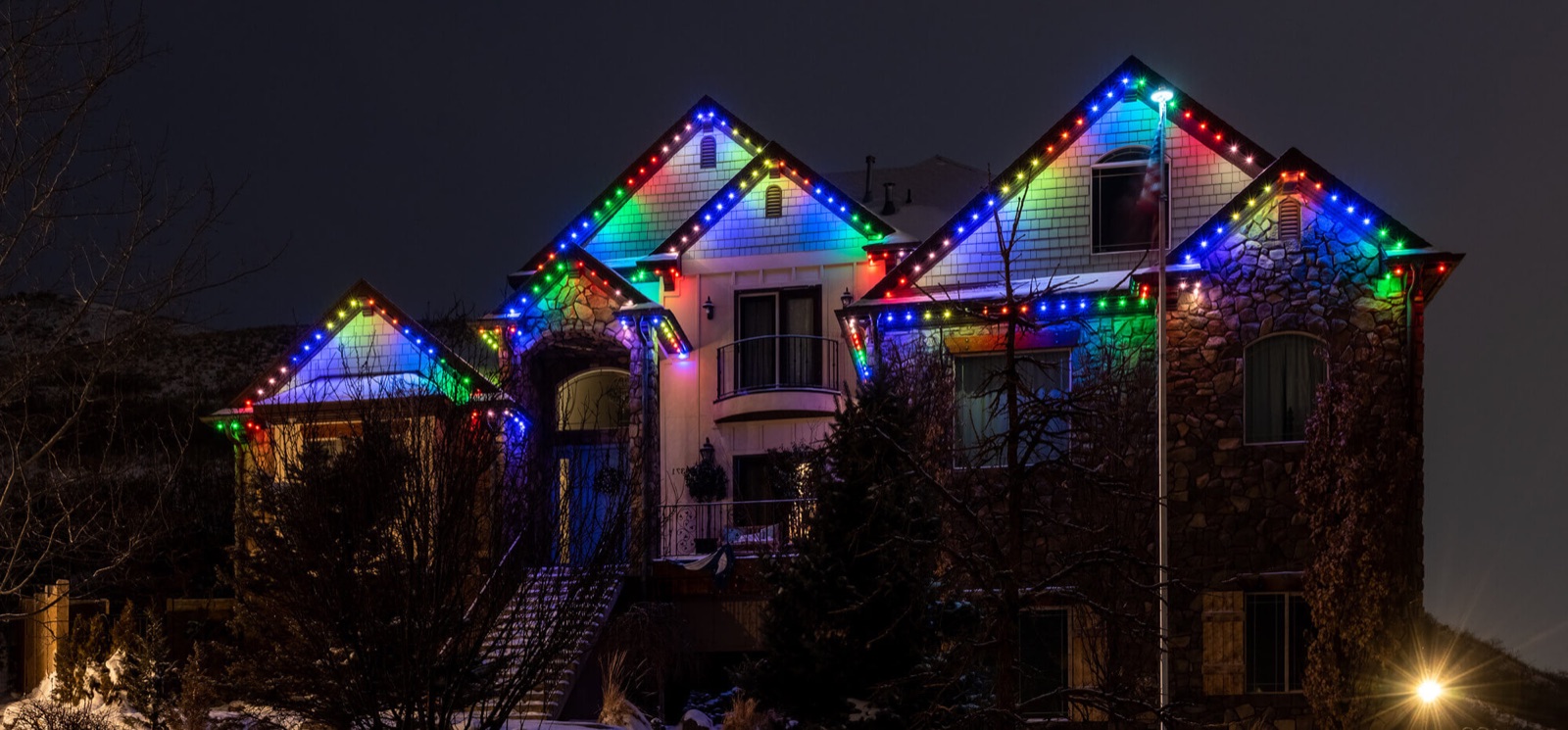 Multicolor permanent roofline lighting on a large home
