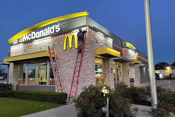Commercial permanent lighting installation crew working from ladders