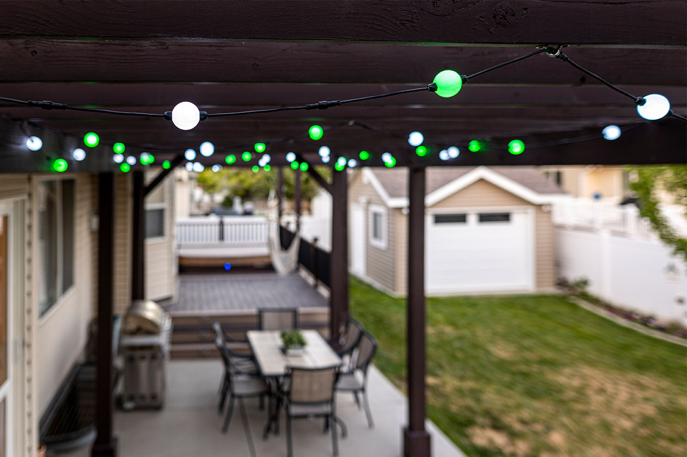 Permanent globe lights installed beneath a residential awning during daytime