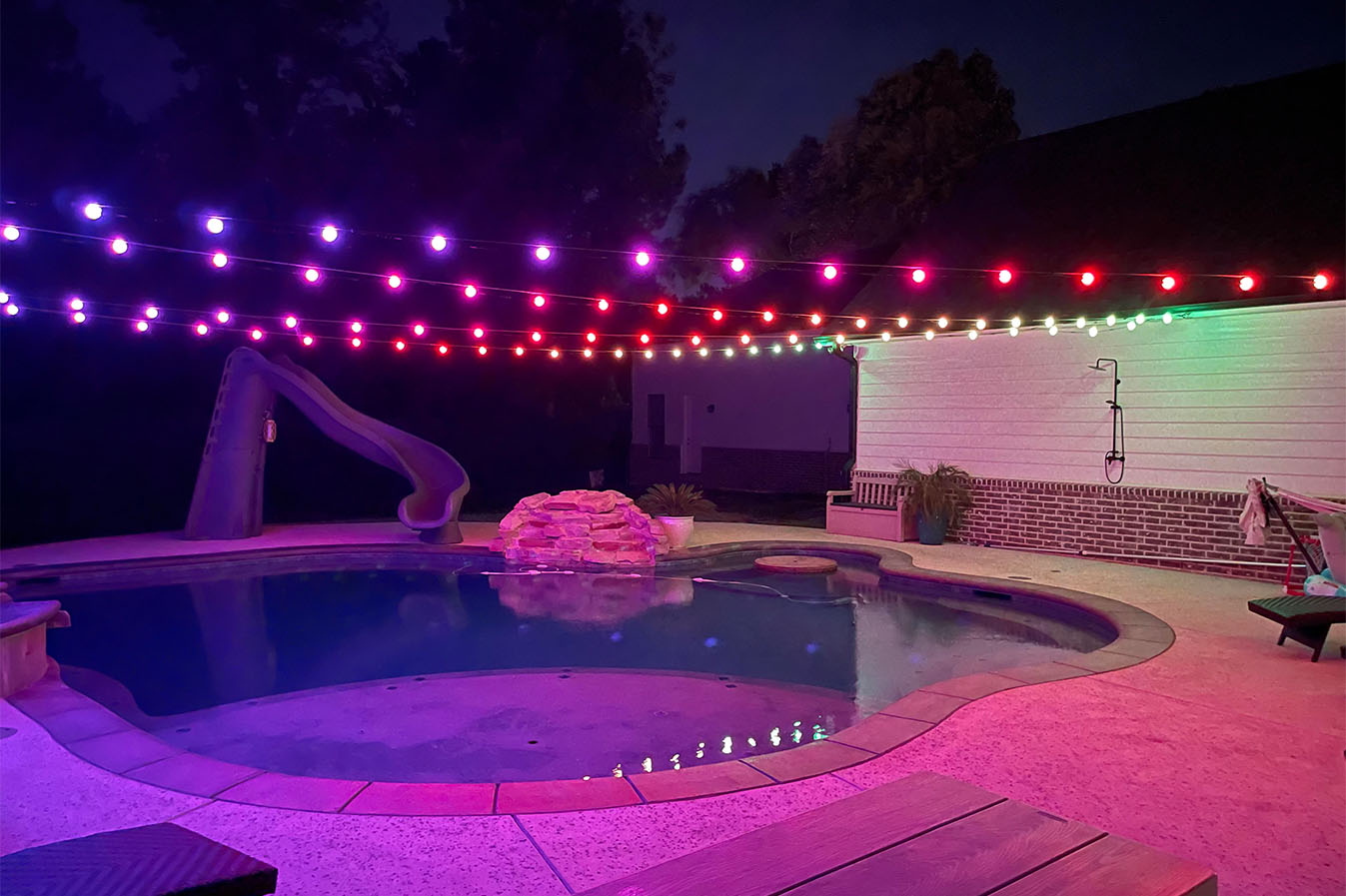 Residential pool beneath colorful globe lights