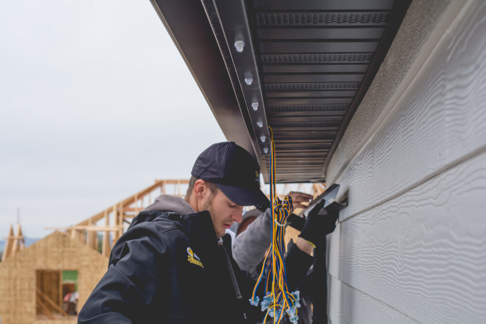Installer accessing a residential roofline