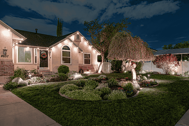 Residential landscape and roofline with warm white lighting
