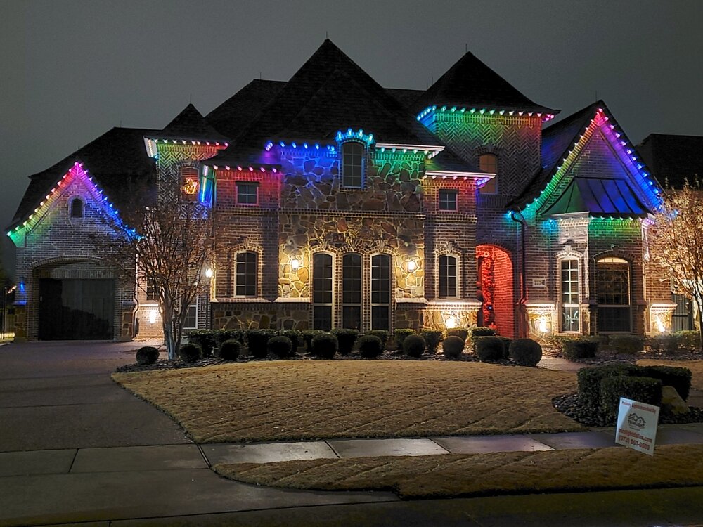 Large residential home with multicolor permanent holiday lighting